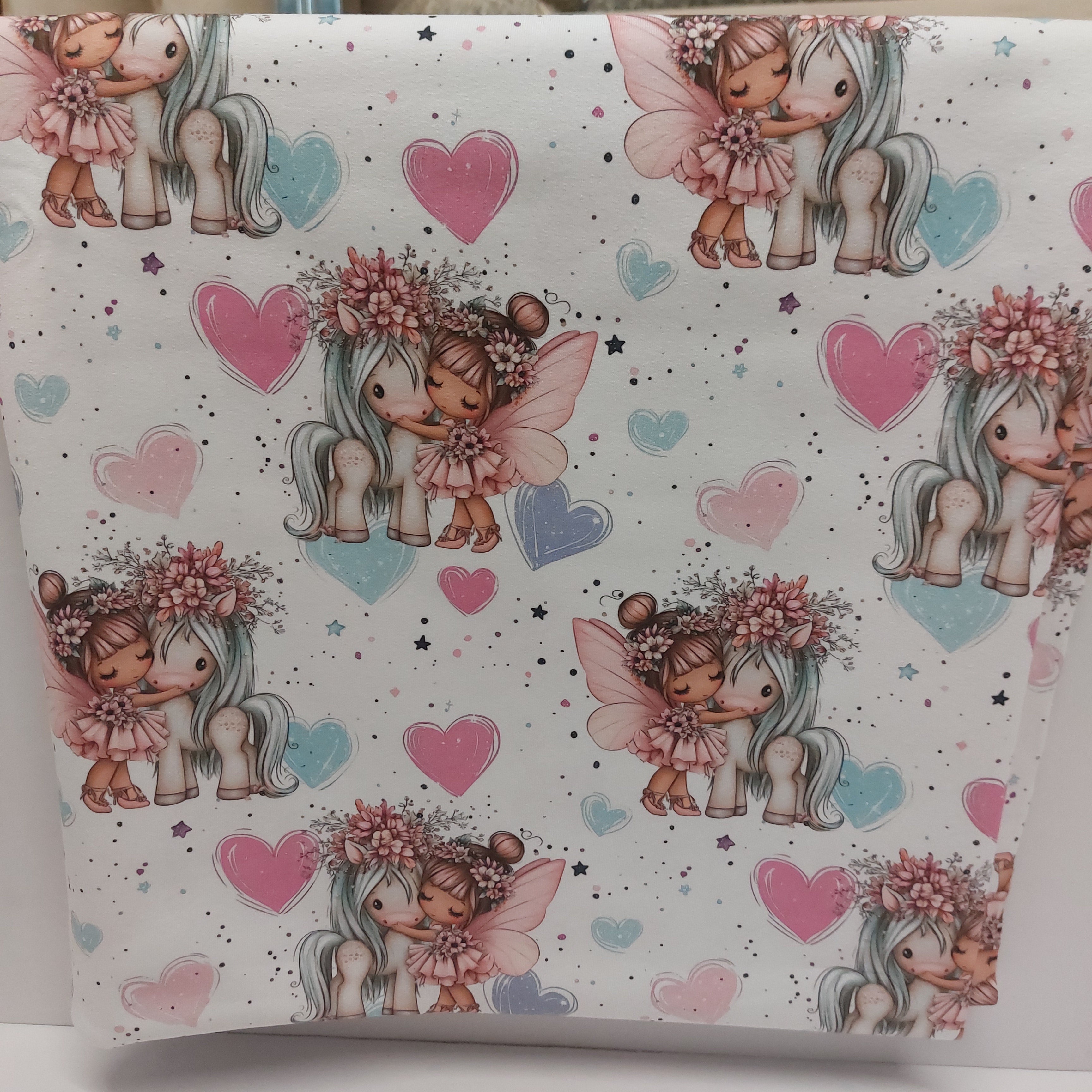 Kleine Fee mit Einhorn und Herzen